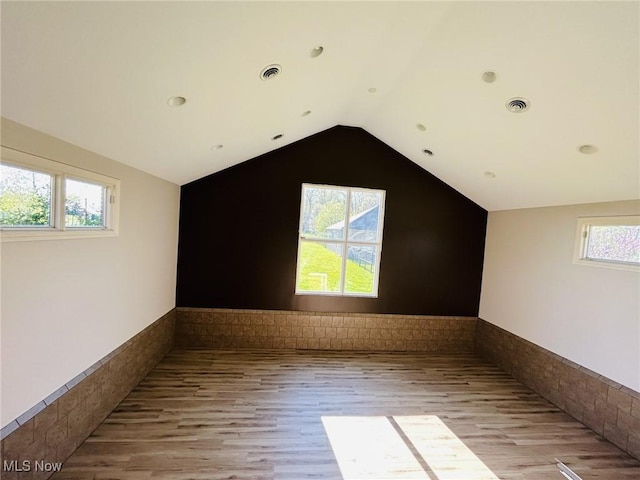 8320 Westfield Rd, Seville, OH 44273 - additional living space featuring light wood-style floors, a wainscoted wall, and vaulted ceiling