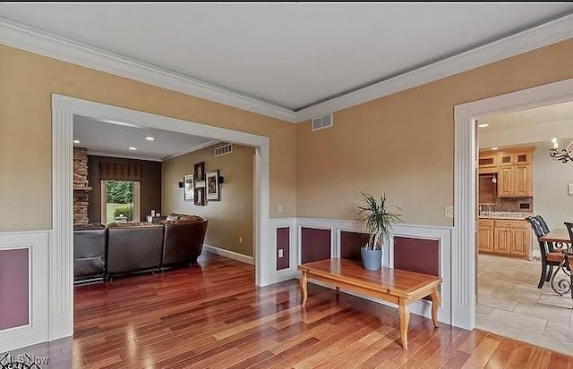8320 Westfield Rd, Seville, OH 44273 - living area featuring crown molding, light wood finished floors, a chandelier, and wainscoting