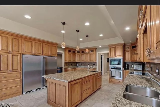 8320 Westfield Rd, Seville, OH 44273 - kitchen featuring built in appliances, a sink, a center island with sink, brown cabinetry, and recessed lighting