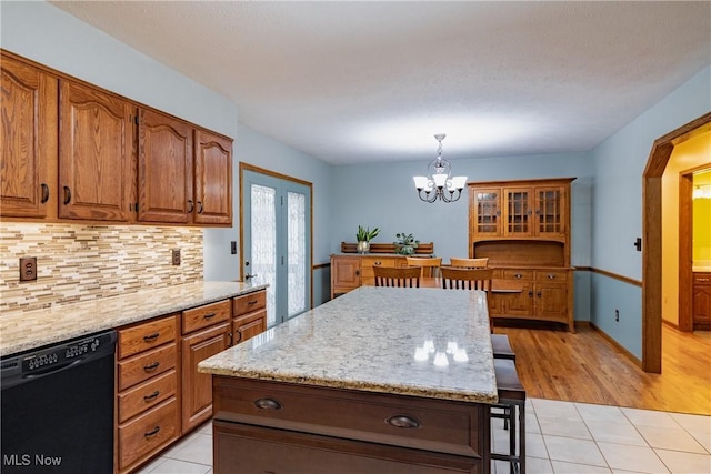 488 Maple Dr, Williamstown, WV 26187 - kitchen with black dishwasher, a chandelier, decorative backsplash, and light tile patterned floors