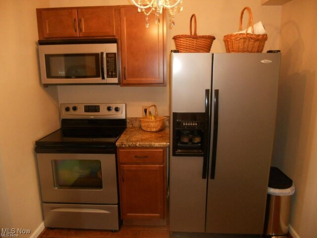 2115 Presidential Pkwy Unit B5, Twinsburg, OH 44087 - kitchen with stainless steel appliances, a chandelier, brown cabinets, and baseboards