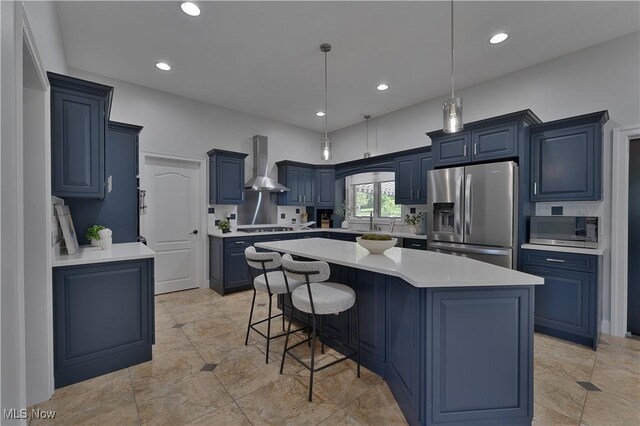 6170 Deer Spring Run, Canfield, OH 44406 - kitchen featuring appliances with stainless steel finishes, wall chimney exhaust hood, blue cabinets, light countertops, and a center island