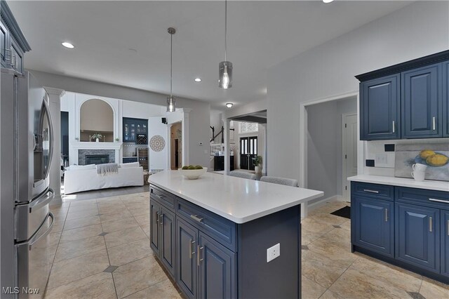 6170 Deer Spring Run, Canfield, OH 44406 - kitchen with stainless steel refrigerator with ice dispenser, blue cabinets, open floor plan, ornate columns, and light countertops