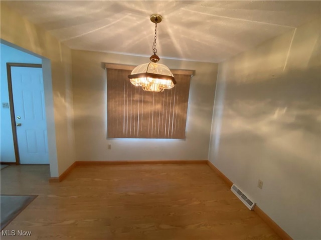 6234 W 54th St, Parma, OH 44129 - unfurnished dining area featuring baseboards, a chandelier, and wood finished floors