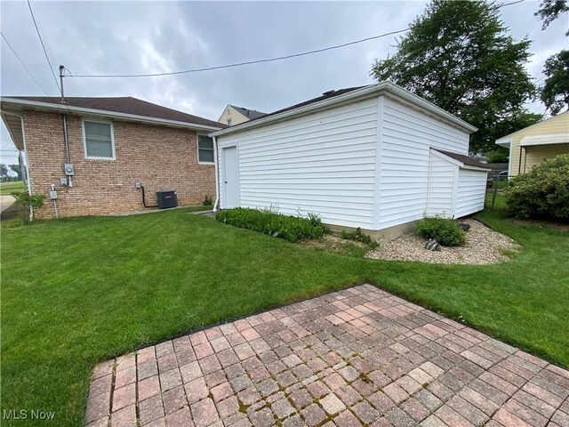 6234 W 54th St, Parma, OH 44129 - rear view of house featuring a lawn, a patio, brick siding, cooling unit, and an outdoor structure