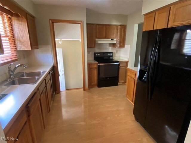 6234 W 54th St, Parma, OH 44129 - kitchen with black appliances, under cabinet range hood, a sink, backsplash, and brown cabinetry