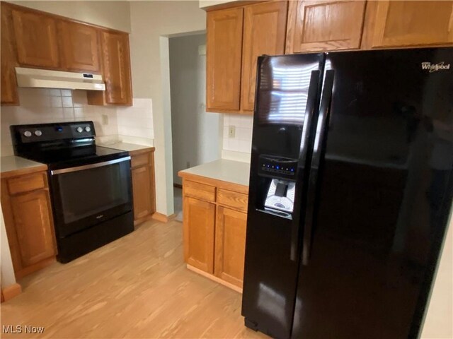 6234 W 54th St, Parma, OH 44129 - kitchen featuring black appliances, under cabinet range hood, tasteful backsplash, and light wood-type flooring