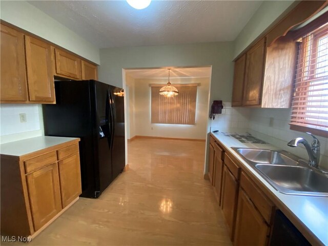 6234 W 54th St, Parma, OH 44129 - kitchen featuring a sink, black fridge with ice dispenser, brown cabinetry, tasteful backsplash, and a textured ceiling
