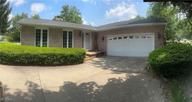 5071 Echoglenn St NW, North Canton, OH 44720 - ranch-style house with brick siding, concrete driveway, a garage, and a chimney