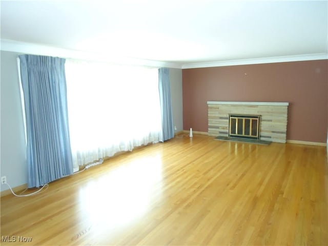 1857 Brainard Rd, Lyndhurst, OH 44124 - unfurnished living room with crown molding, light wood-type flooring, a fireplace with flush hearth, and baseboards