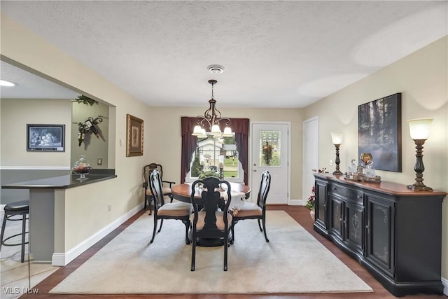 1421 Rolling Meadows Dr, Vermilion, OH 44089 - dining room featuring a chandelier, baseboards, a textured ceiling, and wood finished floors