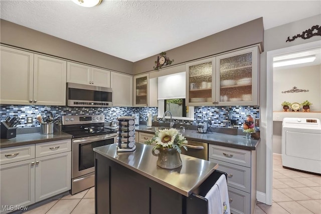 1421 Rolling Meadows Dr, Vermilion, OH 44089 - kitchen with appliances with stainless steel finishes, washer / dryer, light tile patterned flooring, a sink, and a textured ceiling