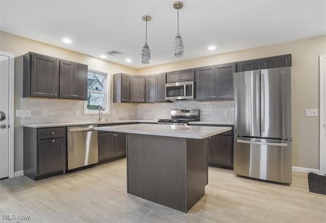 151 E 5th St, Salem, OH 44460 - kitchen featuring appliances with stainless steel finishes, light countertops, dark brown cabinets, backsplash, and hanging light fixtures