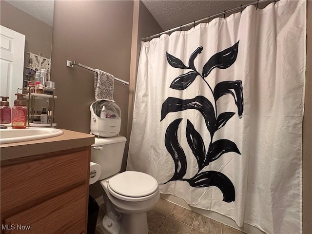 2280 Becket Cir, Stow, OH 44224 - bathroom with a textured ceiling, toilet, vanity, tile patterned floors, and curtained shower