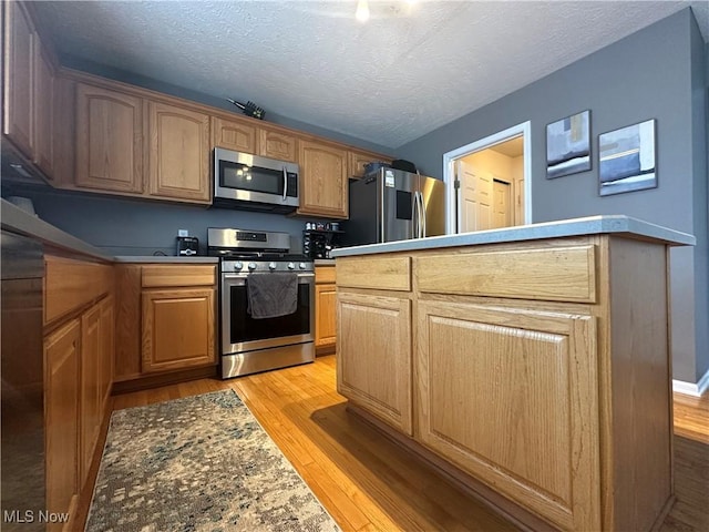 2280 Becket Cir, Stow, OH 44224 - kitchen with stainless steel appliances, light wood-type flooring, a textured ceiling, and baseboards