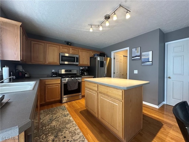 2280 Becket Cir, Stow, OH 44224 - kitchen featuring stainless steel appliances, a sink, a textured ceiling, light wood-style flooring, and a kitchen island