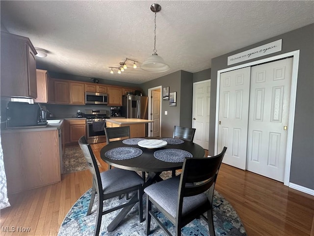 2280 Becket Cir, Stow, OH 44224 - dining area with wood finished floors, a textured ceiling, and baseboards