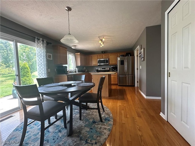 2280 Becket Cir, Stow, OH 44224 - dining room featuring a textured ceiling, wood finished floors, baseboards, and rail lighting