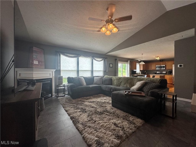 2280 Becket Cir, Stow, OH 44224 - living area featuring a textured ceiling, vaulted ceiling, a ceiling fan, a glass covered fireplace, and baseboards