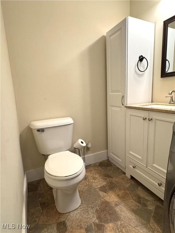 354 Hamilton Ave, Coshocton, OH 43812 - bathroom with vanity, toilet, stone finish floors, and baseboards