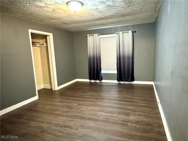 354 Hamilton Ave, Coshocton, OH 43812 - empty room featuring dark wood-type flooring, baseboards, and a textured ceiling
