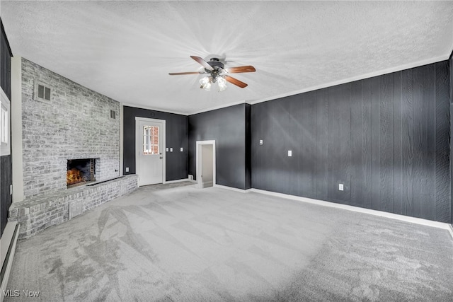 713 Highland Ave, Wadsworth, OH 44281 - unfurnished living room featuring a ceiling fan, carpet floors, a textured ceiling, and a brick fireplace