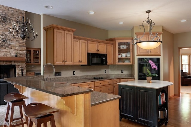 4151 Williamsburg Ct, Medina, OH 44256 - kitchen with a fireplace, black appliances, a sink, glass insert cabinets, and a peninsula