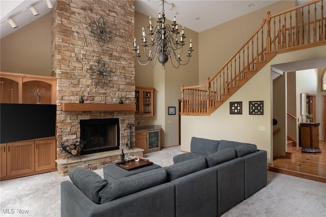 4151 Williamsburg Ct, Medina, OH 44256 - living area with stairs, high vaulted ceiling, light colored carpet, rail lighting, and a fireplace