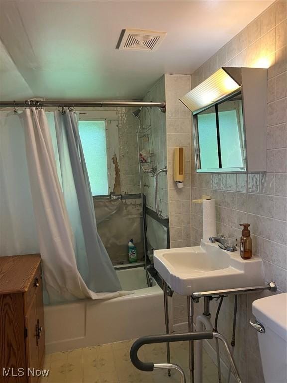 1723 W Prospect Rd, Ashtabula, OH 44004 - full bathroom with tile walls, shower / bath combination with curtain, toilet, and tile patterned floors