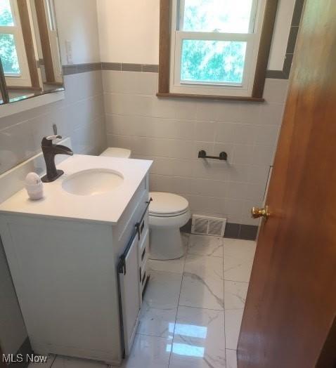 307 Township Road 245, Toronto, OH 43964 - bathroom featuring tile walls, vanity, toilet, marble finish flooring, and a wainscoted wall