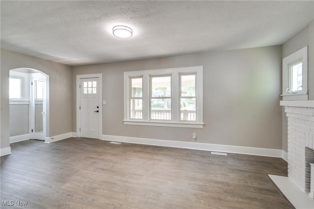 1260 Beardsley St, Akron, OH 44301 - foyer with a fireplace, wood finished floors, healthy amount of natural light, baseboards, and a textured ceiling