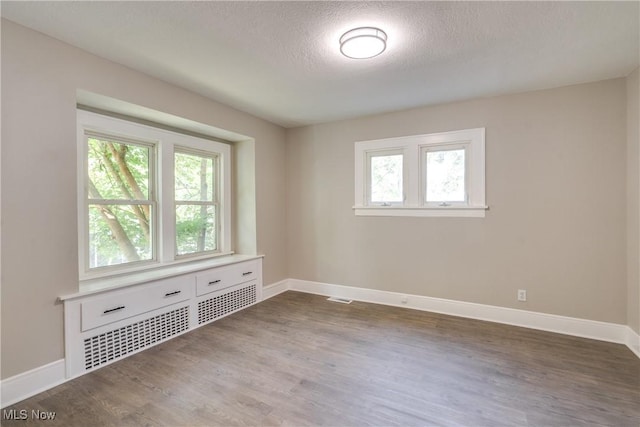 1260 Beardsley St, Akron, OH 44301 - empty room with wood finished floors, a textured ceiling, and baseboards