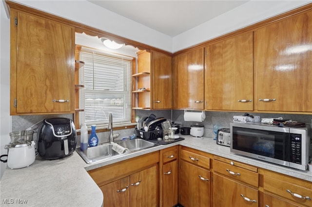 20800 Wilmore Ave, Euclid, OH 44123 - kitchen featuring stainless steel microwave, a sink, light countertops, and brown cabinets
