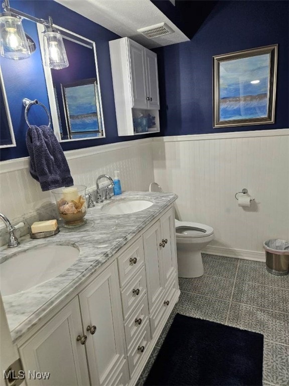 110 Olson Spur, Munroe Falls, OH 44262 - full bathroom featuring a wainscoted wall, double vanity, and toilet