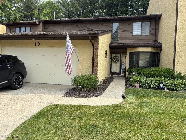 110 Olson Spur, Munroe Falls, OH 44262 - multi unit property featuring driveway, stucco siding, a garage, and a front yard