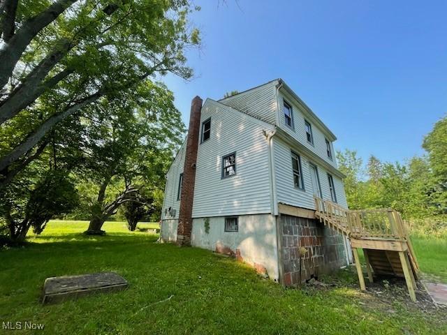 15262 Wadsworth Rittman Rd, Rittman, OH 44270 - view of property exterior with a chimney, a lawn, a wooden deck, and stairs