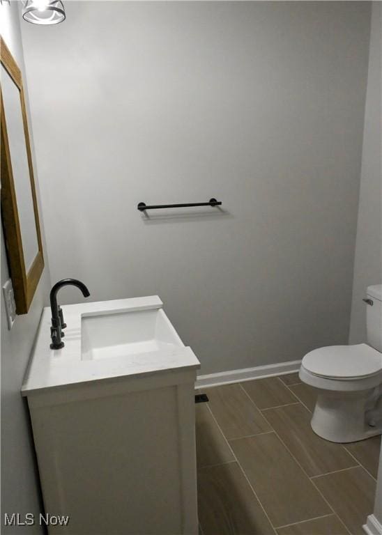 2948 Maple Ave NE, Canton, OH 44714 - half bathroom featuring vanity, toilet, and baseboards