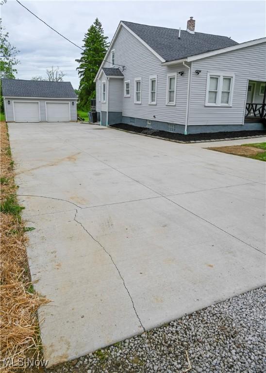 2948 Maple Ave NE, Canton, OH 44714 - view of side of property with a garage, a chimney, an outbuilding, and roof with shingles