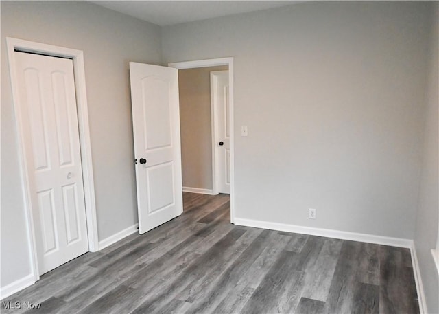 2948 Maple Ave NE, Canton, OH 44714 - unfurnished bedroom featuring dark wood-style flooring and baseboards