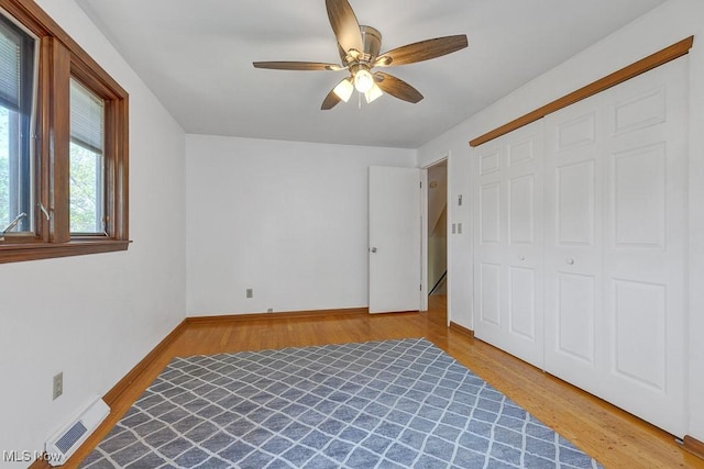 1825 E Skyline Dr, Lorain, OH 44053 - unfurnished bedroom with wood finished floors, a closet, baseboards, and ceiling fan