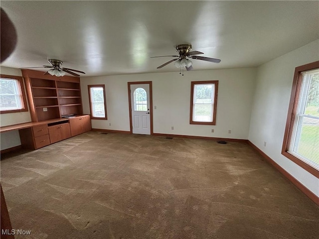 8973 Matty Rd, West Salem, OH 44287 - unfurnished living room featuring a ceiling fan, light colored carpet, baseboards, and healthy amount of natural light