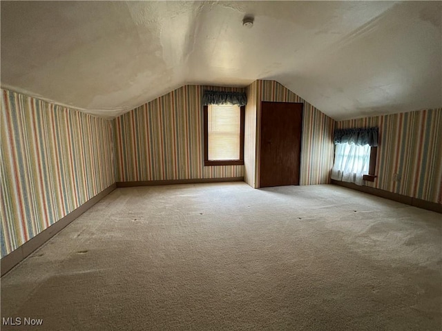 8973 Matty Rd, West Salem, OH 44287 - additional living space with wallpapered walls, vaulted ceiling, and light colored carpet