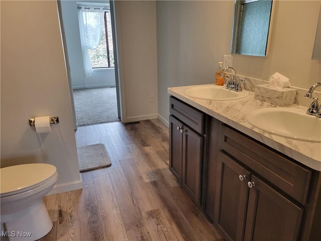1110 By The Shores Dr, Huron, OH 44839 - bathroom featuring baseboards, double vanity, wood finished floors, and toilet