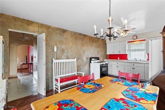 157 W 45th St, Shadyside, OH 43947 - dining room with arched walkways, a chandelier, ceiling fan, dark wood finished floors, and tile walls
