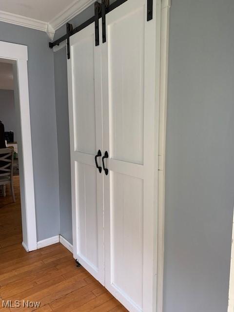 1209 N 4th St, Toronto, OH 43964 - detailed view of a barn door, crown molding, and wood finished floors