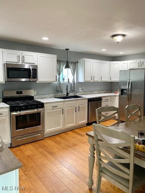 1209 N 4th St, Toronto, OH 43964 - kitchen with stainless steel appliances, white cabinets, recessed lighting, pendant lighting, and light wood-type flooring