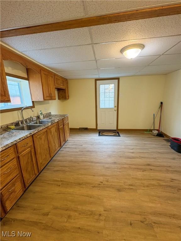 1019 Commerce St, Wellsville, OH 43968 - kitchen featuring light wood-style floors, brown cabinetry, plenty of natural light, and a drop ceiling