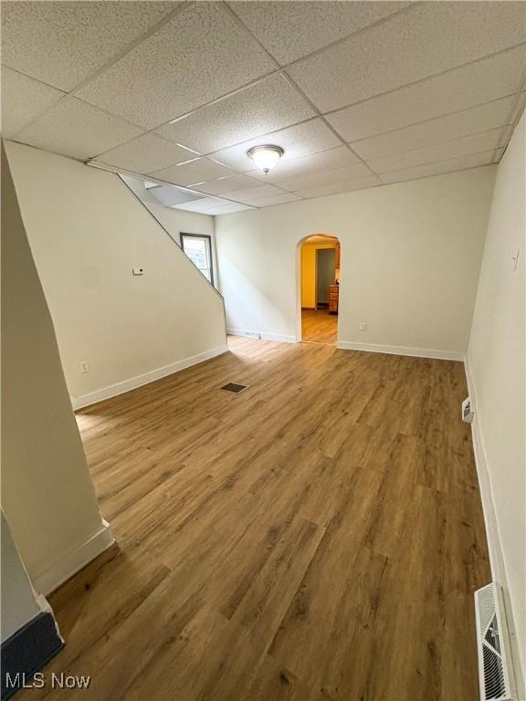1019 Commerce St, Wellsville, OH 43968 - unfurnished room with arched walkways, a drop ceiling, and wood finished floors