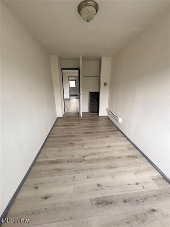 1019 Commerce St, Wellsville, OH 43968 - unfurnished living room with a baseboard heating unit and wood finished floors
