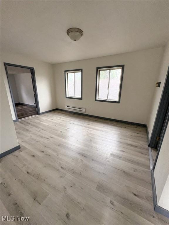 1019 Commerce St, Wellsville, OH 43968 - unfurnished room featuring a baseboard heating unit and light wood-type flooring